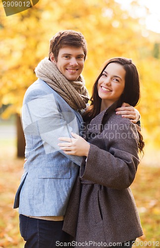 Image of smiling couple hugging in autumn park