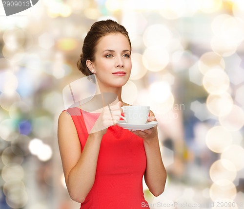 Image of smiling woman in red dress with cup of coffee