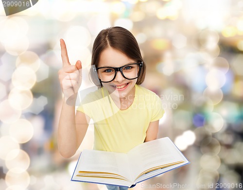 Image of smiling little girl in eyeglasses with book