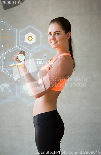 Image of smiling woman with dumbbells in gym