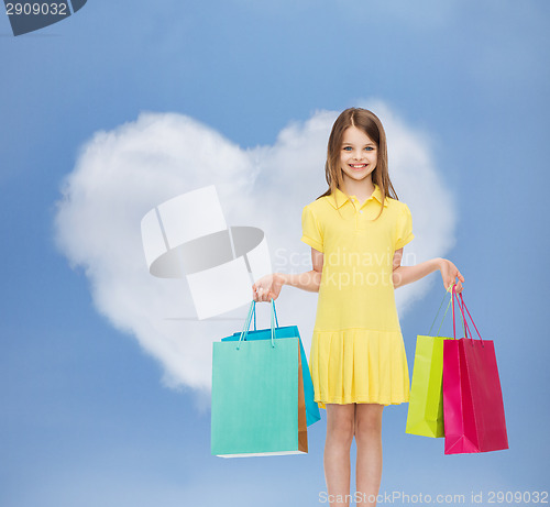 Image of smiling little girl in dress with shopping bags
