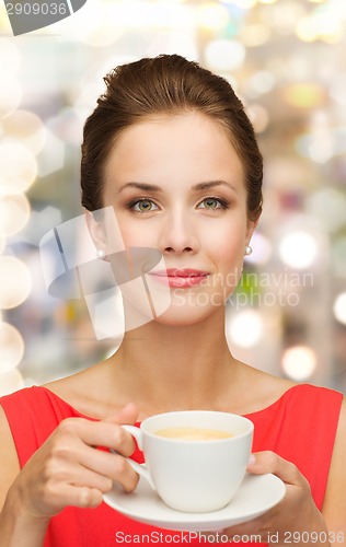 Image of smiling woman in red dress with cup of coffee