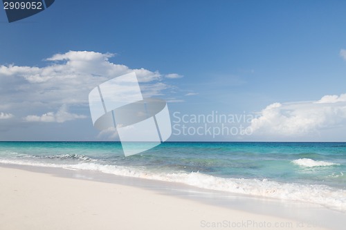 Image of blue sea or ocean, white sand and sky with clouds