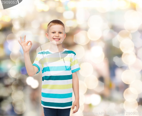 Image of little boy in casual clothes making OK gesture