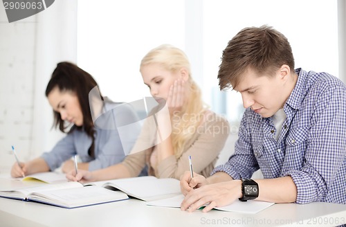 Image of tired students with notebooks at school