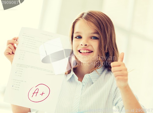 Image of smiling little student girl with test and A grade