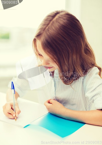 Image of student girl writing in notebook at school