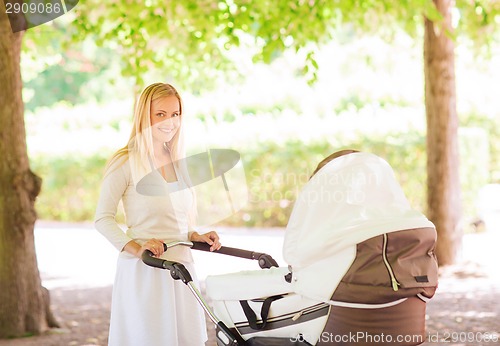 Image of happy mother with stroller in park