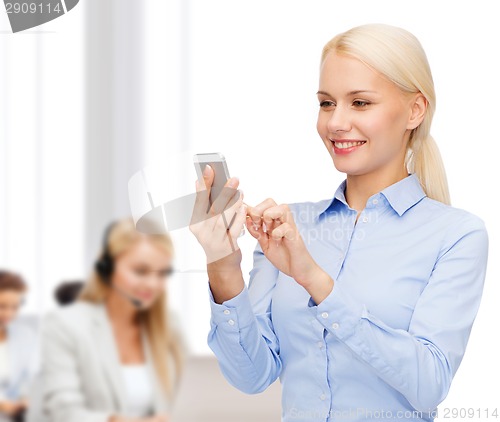 Image of young smiling businesswoman with smartphone