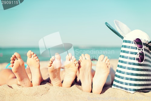 Image of three women lying on the beach