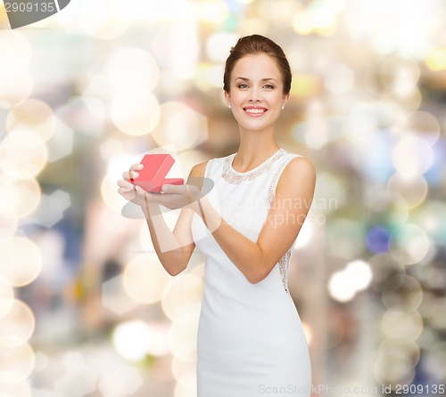 Image of smiling woman holding red gift box