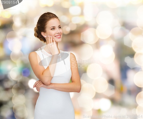 Image of smiling woman in white dress wearing diamond ring