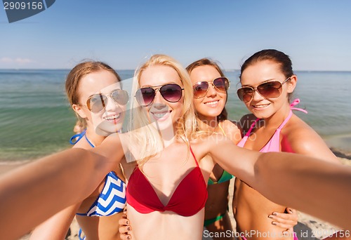 Image of group of young smiling women making selfie