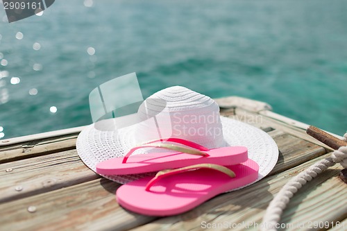 Image of close up of hat and slippers at seaside