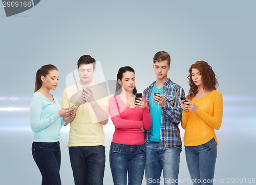 Image of group of serious teenagers with smartphones