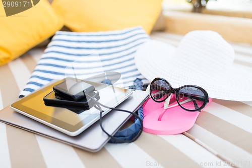 Image of close up of tablet pc and smartphone on beach