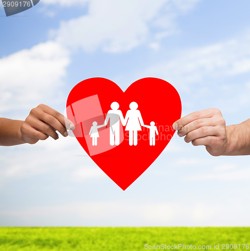 Image of couple hands holding red heart with family