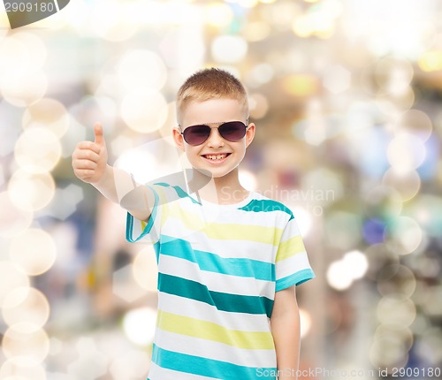 Image of smiling little boy in sunglasses showing thumbs up