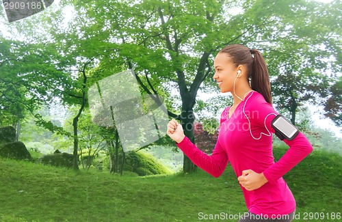 Image of smiling young woman running outdoors