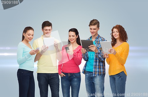 Image of group of teenagers with smartphones and tablet pc