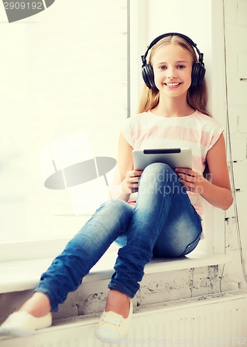 Image of girl with tablet pc and headphones at home