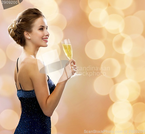 Image of smiling woman holding glass of sparkling wine