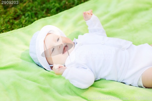 Image of smiling baby lying on floor and looking up