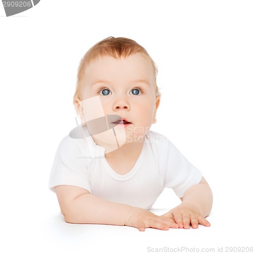 Image of curious baby lying on floor and looking up