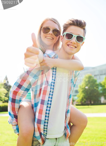 Image of smiling couple having fun and showing thumbs up