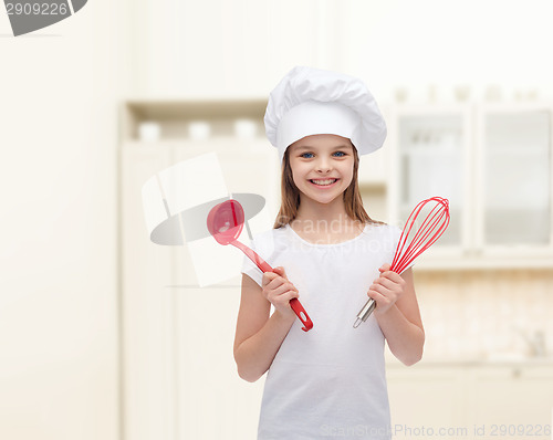 Image of smiling girl in cook hat with ladle and whisk