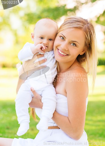 Image of happy mother with little baby sitting on blanket