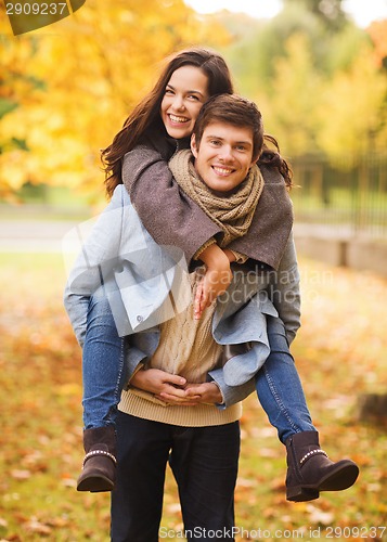 Image of smiling couple hugging in autumn park