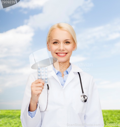 Image of smiling female doctor with pills