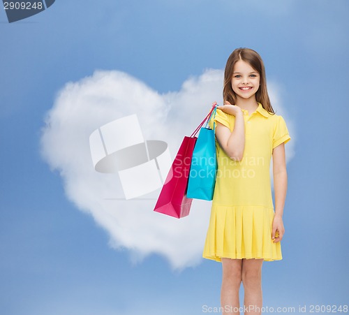 Image of smiling little girl in dress with shopping bags