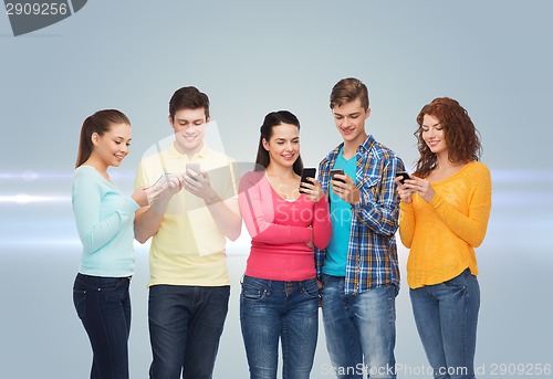 Image of group of smiling teenagers with smartphones