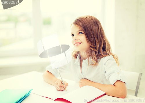 Image of student girl writing in notebook at school