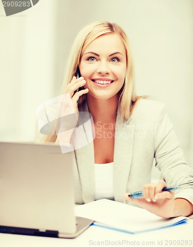 Image of businesswoman with laptop and cell phone