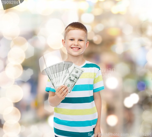 Image of smiling boy holding dollar cash money in his hand