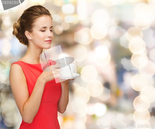 Image of smiling woman in red dress with cup of coffee