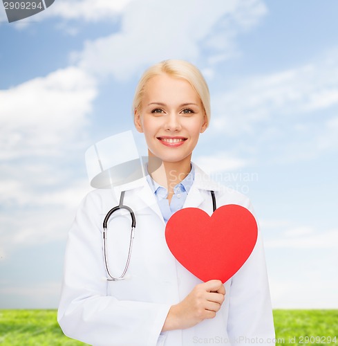 Image of smiling female doctor with heart and stethoscope