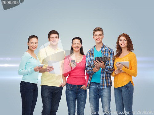 Image of group of teenagers with smartphones and tablet pc