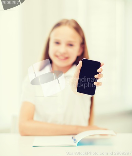 Image of smiling student girl with smartphone at school