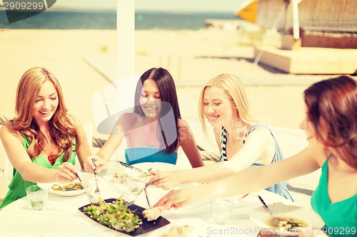 Image of smiling girls in cafe on the beach