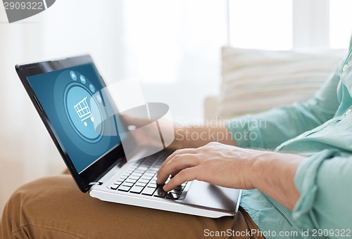 Image of close up of man working with laptop at home