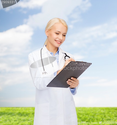 Image of smiling female doctor with clipboard