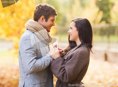 Image of close up of smiling couple with gift box in park