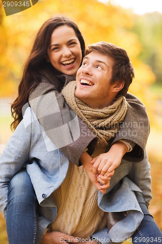 Image of smiling couple hugging in autumn park