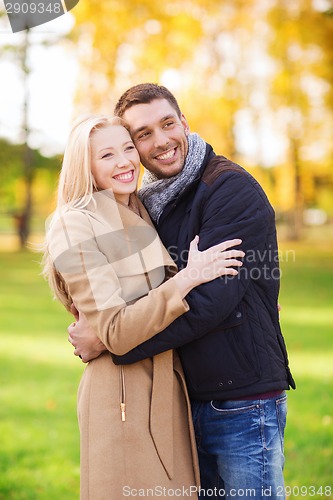 Image of smiling couple hugging in autumn park