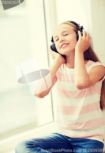 Image of little girl with headphones at home