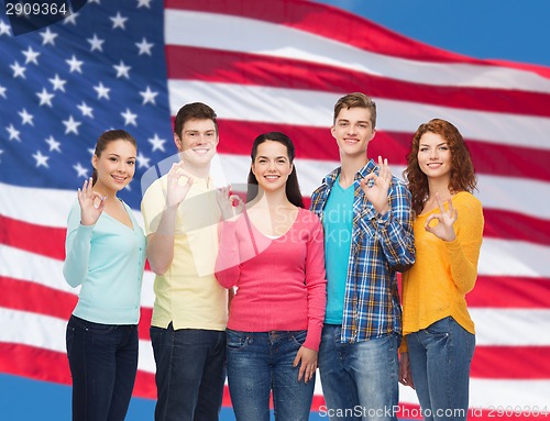 Image of group of smiling teenagers over american flag